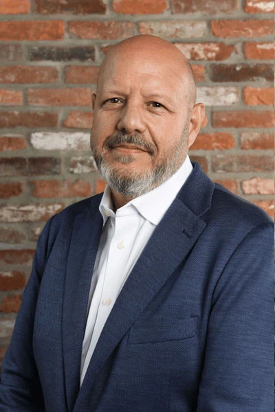 Portrait of a man with a confident expression, standing in front of the Datafield Technology Services logo. The man, identified as Courtland Bishop, appears to be a prominent figure associated with the company.