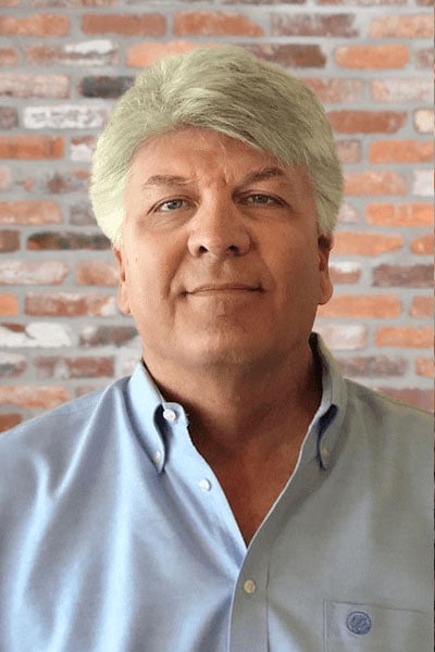 Portrait of a man standing confidently, with the logo of Datafield Technology Services visible in the background. The man, identified as Michael Norris, appears to be a key figure associated with the company.