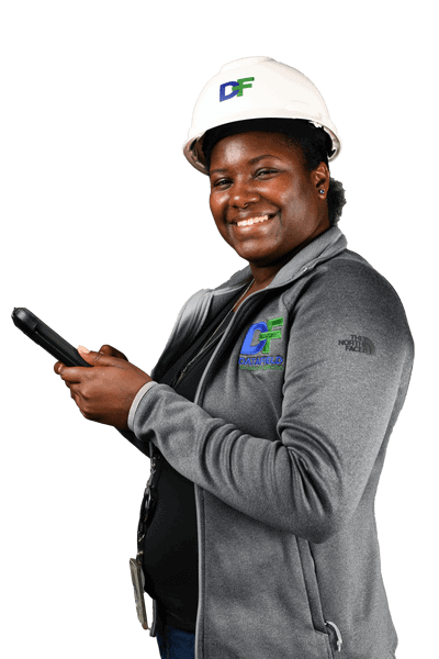 A woman wearing a hard hat and holding a cell phone, featuring Data Field Technology Services and highlighting their expertise in innovative tech solutions.