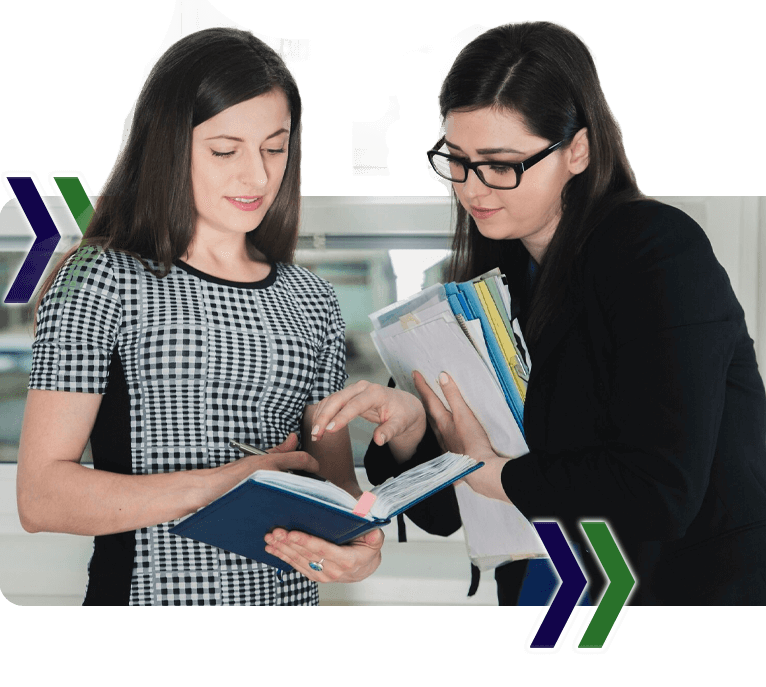 Two women are looking at a book and writing on it, featuring Data Field Technology Services and highlighting their expertise in innovative tech solutions.